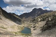 Výhled ze sedla Cuello de Brazato na další jezírko a za ním nejvyšší horu francouzských Pyrenejí - Vignemale (3298 m n. m.).